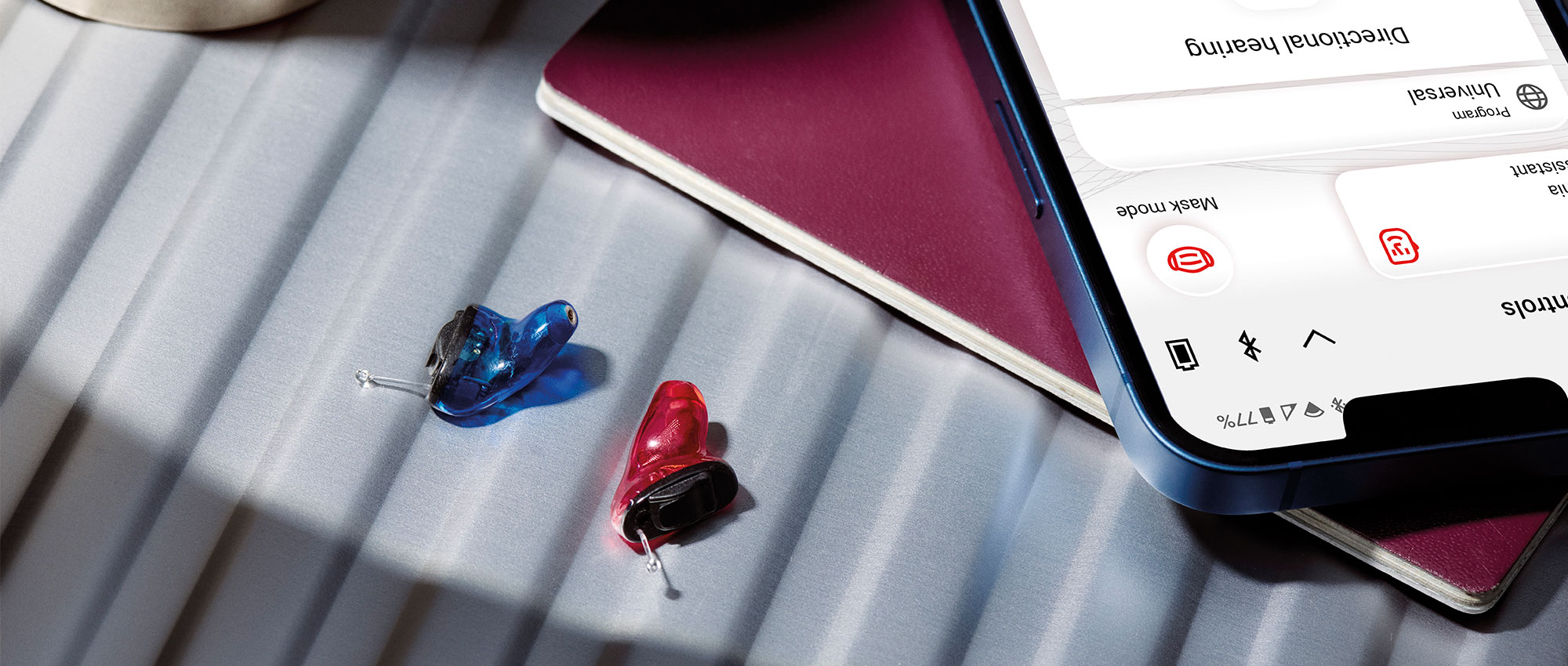 Insio IX Hörgeräte von Signia neben einem Smartphone. Mit Bluetooth-Funktion für nahtlose Verbindung und personalisierte Steuerung. Insio IX Hörgeräte von Signia neben einem Smartphone. Mit Bluetooth-Funktion für nahtlose Verbindung und personalisierte Steuerung.