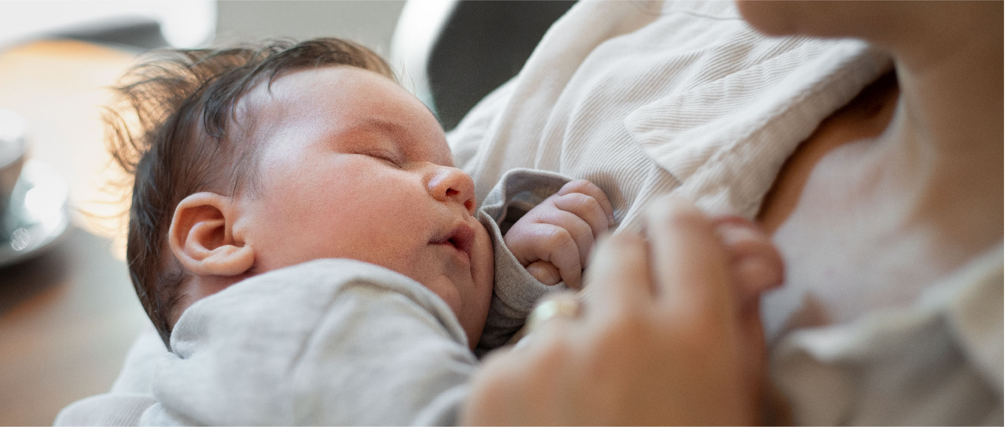 Ein schlafendes Baby in den Armen der Mutter. Sanfte Schlafunterstützung für Gehörlose durch das Vibio Vibrationskissen, das weckt, ohne lauten Alarm. Ein schlafendes Baby in den Armen der Mutter. Sanfte Schlafunterstützung für Gehörlose durch das Vibio Vibrationskissen, das weckt, ohne lauten Alarm.