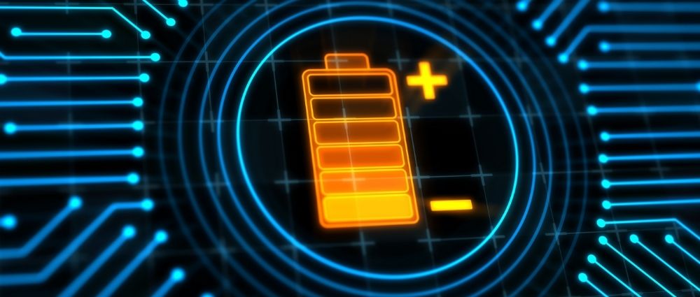 Leuchtende orange Batterieanzeige mit Plus- und Minuszeichen auf blauem elektronischem Schaltkreis zeigt Akkustand​​​​​​​​​​​​​​​​​​​​​​​​​​​​​​​