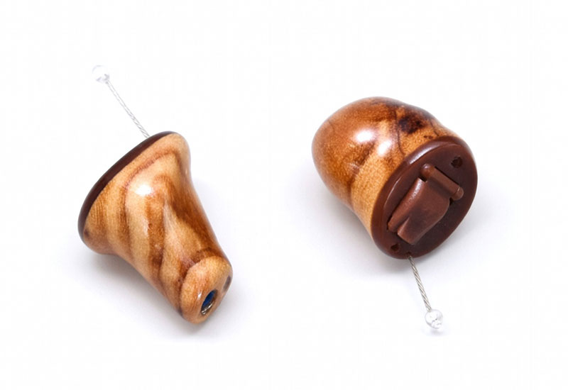 Zwei handgefertigte Ohrhörer aus Holz mit sichtbarer Maserung auf weißem Hintergrund, detailreich und natürlich​​​​​​​​​​​​​​​​​​​​​​​​​​​​​​​​​​