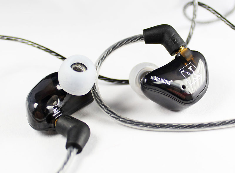 Nahaufnahme von schwarzen In-Ear Gehörschutz Ohrhörern mit transparentem Kabel auf weißem Hintergrund​​​​​​​​​​​​​​​​​​​​​​​​​​​​​​​​​​​​​​​​​​​​