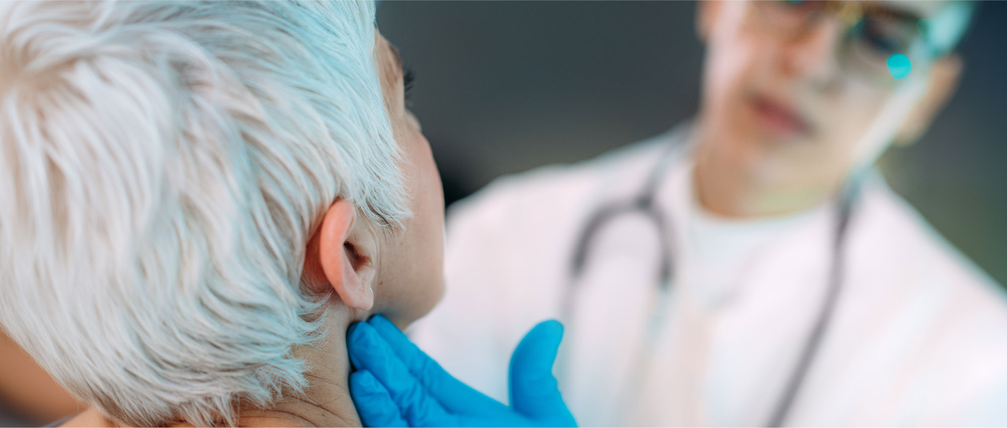 Ein Arzt mit blauen Handschuhen untersucht das Ohr eines älteren Patienten in einer medizinischen Praxis. HNO-Untersuchung.​​​​​​​​​​​​​​​​​​​​​​