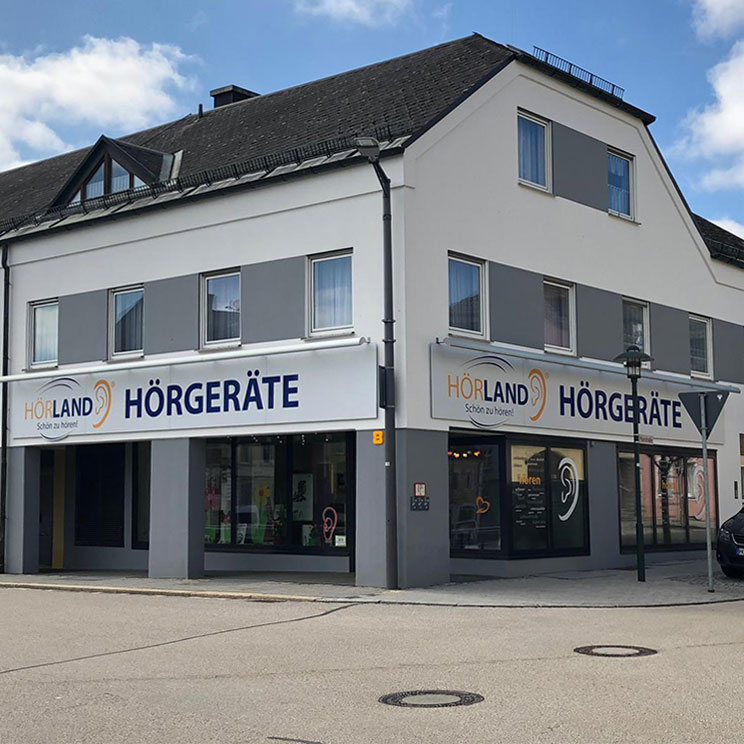 Fachgeschäft Hörland Hörgeräte in Rehau mit moderner Außenfassade an sonnigem Tag an der Straßenecke​​​​​​​​​​​​​​​​​​​​​​​​​​​​​​​​​​​​​​​​​​​​​
