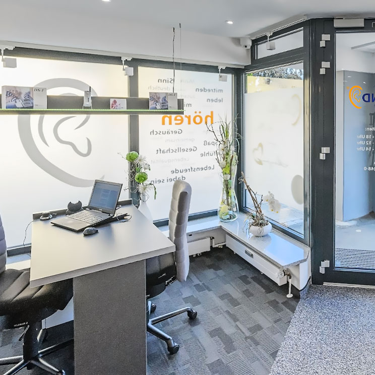 Moderner Empfangsbereich mit Laptop, Bürostühlen und großen Fenstern in einem Hörgerätegeschäft in Rehau.​​​​​​​​​​​​​​​​​​​​​​​​​​​​​​​​​​​​​​​​