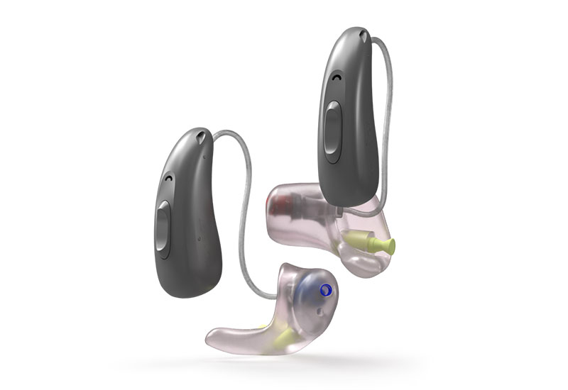Zwei graue Hörgeräte mit transparenten Ohrpassstücken vor weißem Hintergrund, modernes Design für Hörkomfort.​​​​​​​​​​​​​​​​​​​​​​​​​​​​​​​​​​​​