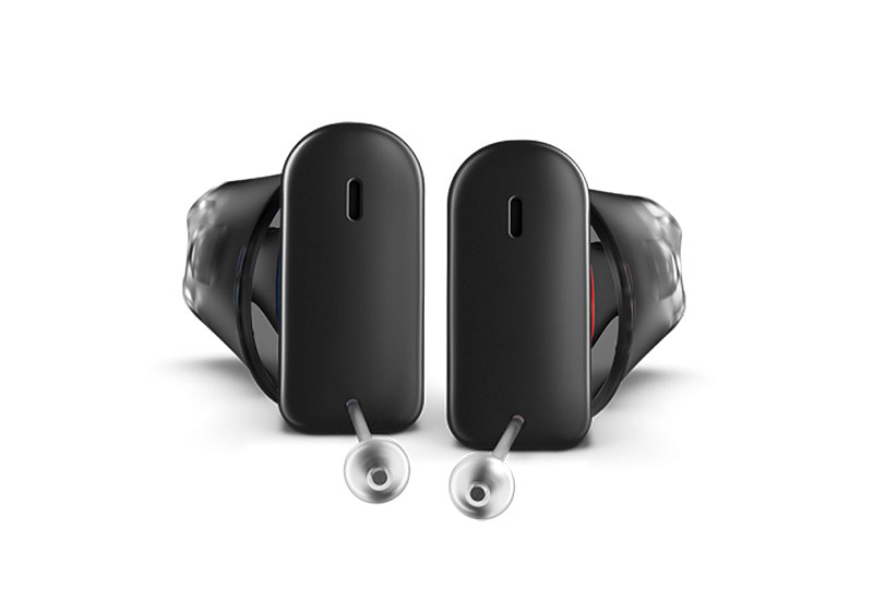 Nahaufnahme von schwarzen Komfort Hörgeräten vor weißem Hintergrund, modernes Design und klare Formgebung sichtbar.​​​​​​​​​​​​​​​​​​​​​​​​​​​​​​