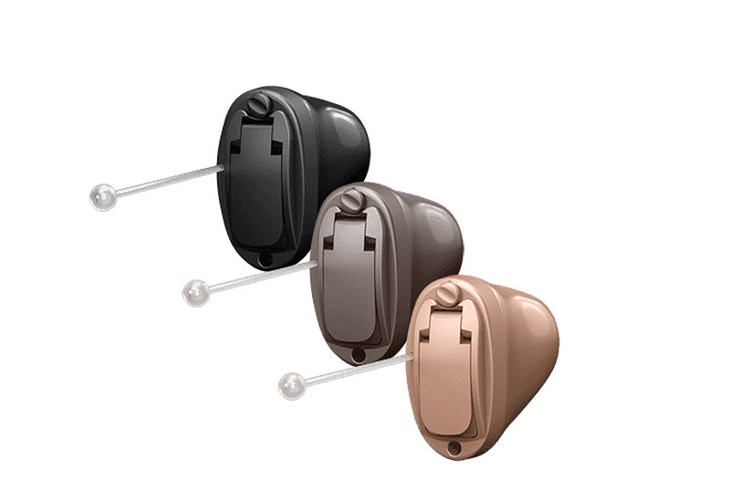 Drei verschiedene Basis-Hörgeräte in Schwarz, Braun und Beige auf weißem Hintergrund, kompakte Modelle für Hörkomfort.​​​​​​​​​​​​​​​​​​​​​​​​​​​