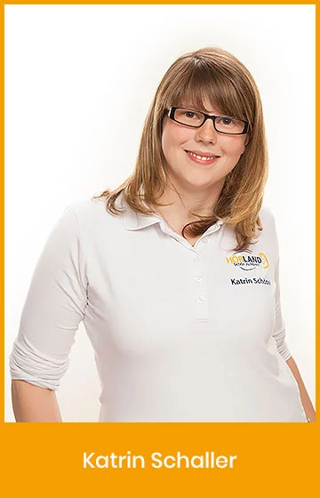 Katrin Schaller, Mitarbeiterin der Hörland Filiale, lächelt in die Kamera und trägt ein weißes Polo-Shirt mit Firmenlogo.