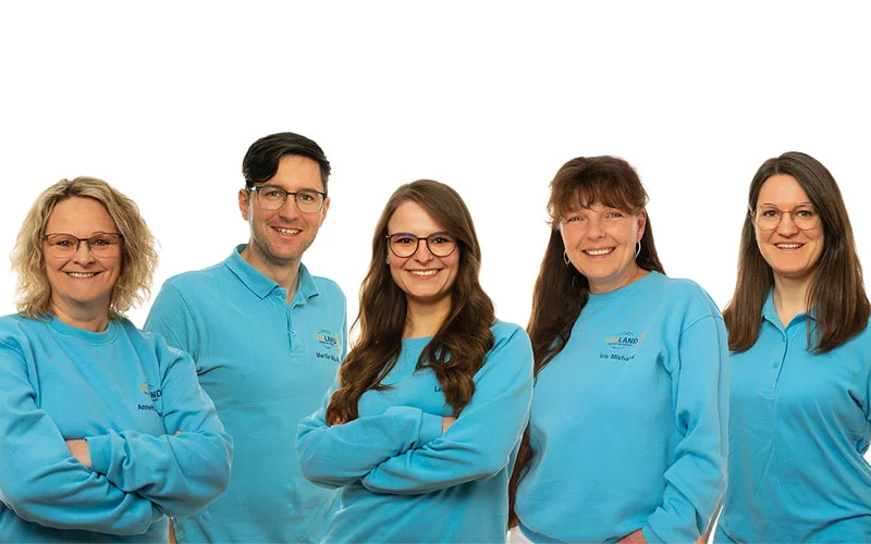 Team der Hörland Filiale in Münchberg, bestehend aus drei Mitarbeitern, die in weißen Polo-Shirts mit dem Hörland Logo lächeln.