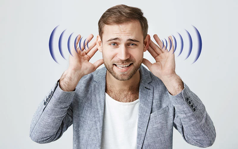 Mann hält sich die Ohren, dargestellt mit Schallwellen, um Hörprobleme zu veranschaulichen.