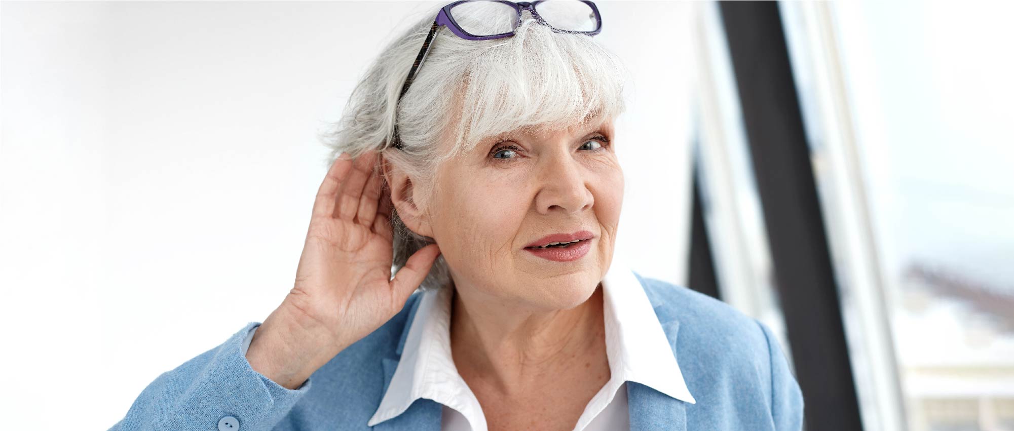 Ältere Dame, die ihre Hand ans Ohr hält, ein häufiges Zeichen für beginnende Schwerhörigkeit. Aufklärung über die Bedeutung von Hörtests und Hörgeräten zur Vermeidung von sozialer Isolation. Ältere Dame, die ihre Hand ans Ohr hält, ein häufiges Zeichen für beginnende Schwerhörigkeit. Aufklärung über die Bedeutung von Hörtests und Hörgeräten zur Vermeidung von sozialer Isolation.