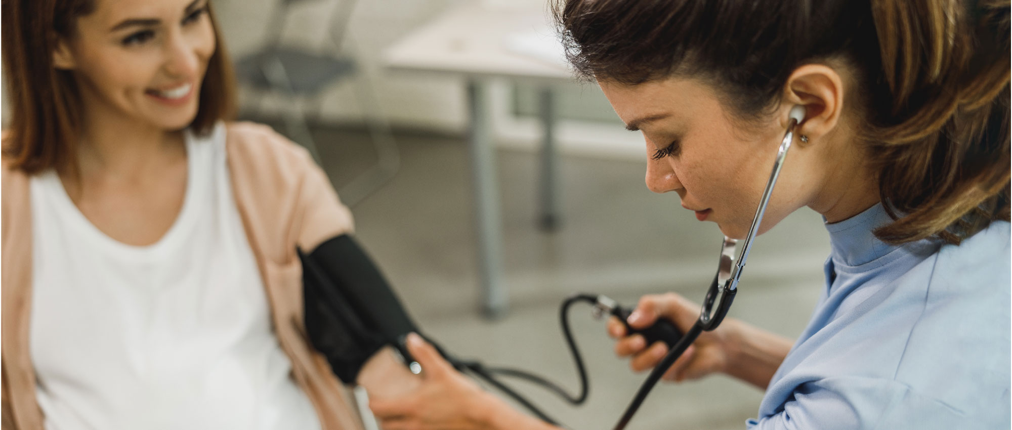 Schwangere Frau bei einer Blutdruckmessung. Ein erhöhter Blutdruck während der Schwangerschaft kann Tinnitus-Symptome verursachen. Hörland Hörakustik bietet Informationen und Beratung zu Tinnitus in der Schwangerschaft. Schwangere Frau bei einer Blutdruckmessung. Ein erhöhter Blutdruck während der Schwangerschaft kann Tinnitus-Symptome verursachen. Hörland Hörakustik bietet Informationen und Beratung zu Tinnitus in der Schwangerschaft.