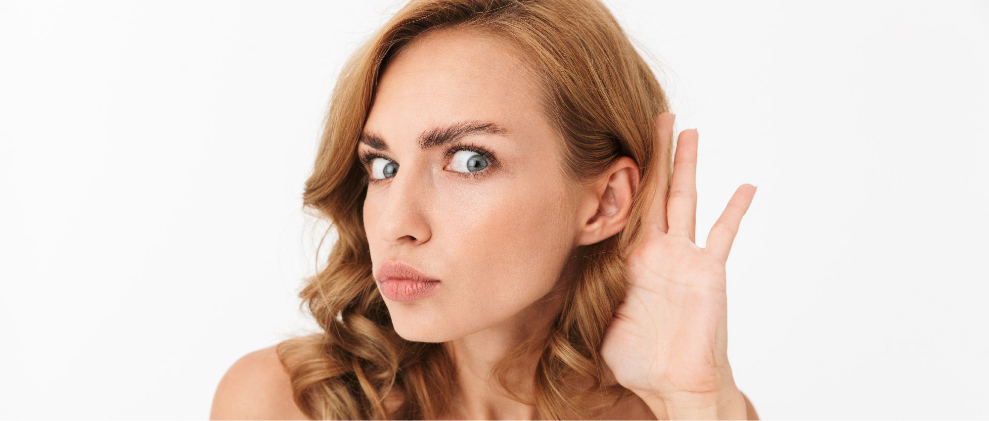 Eine Frau hält die Hand am Ohr und versucht, besser zu hören. Das Bild zeigt mögliche Anzeichen von Hörverlust und erinnert daran, wie wichtig es ist, Hörtests regelmäßig durchzuführen, um Schwerhörigkeit frühzeitig zu erkennen. Eine Frau hält die Hand am Ohr und versucht, besser zu hören. Das Bild zeigt mögliche Anzeichen von Hörverlust und erinnert daran, wie wichtig es ist, Hörtests regelmäßig durchzuführen, um Schwerhörigkeit frühzeitig zu erkennen.