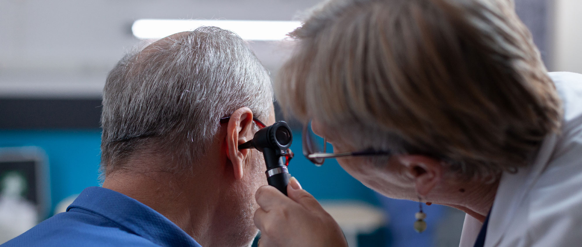 Ärztin untersucht das Ohr eines älteren Mannes, um mögliche Ursachen für Schwindel zu diagnostizieren – mehr über Ohrenerkrankungen und Schwindelprävention auf Hoerland. Ärztin untersucht das Ohr eines älteren Mannes, um mögliche Ursachen für Schwindel zu diagnostizieren – mehr über Ohrenerkrankungen und Schwindelprävention auf Hoerland.