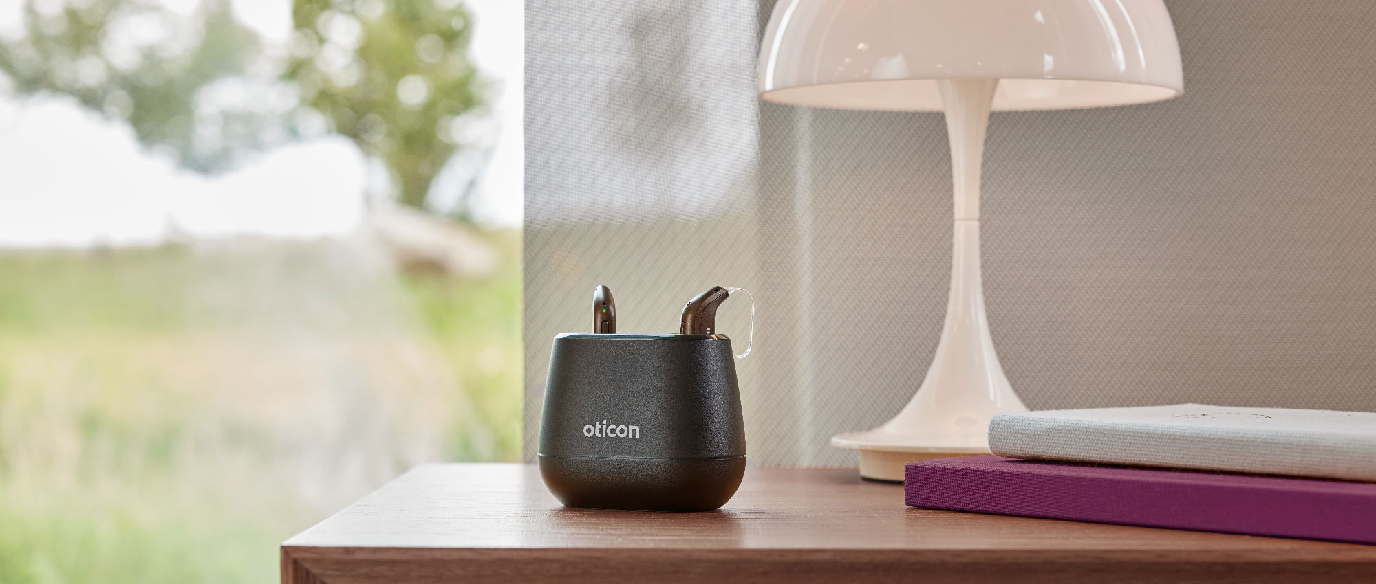 Hörgeräte in einer Ladestation auf einem Tisch, empfohlen für den täglichen Gebrauch mit regelmäßigen Tragepausen. Hörgeräte in einer Ladestation auf einem Tisch, empfohlen für den täglichen Gebrauch mit regelmäßigen Tragepausen.